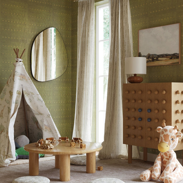 Frameless blob-shaped wall mirror styled in a nursery room above a wooden play area, reflecting natural light from a window.