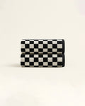 Two black and white checkered towels neatly rolled and stacked, showcasing the geometric pattern and soft terry texture on a neutral background.