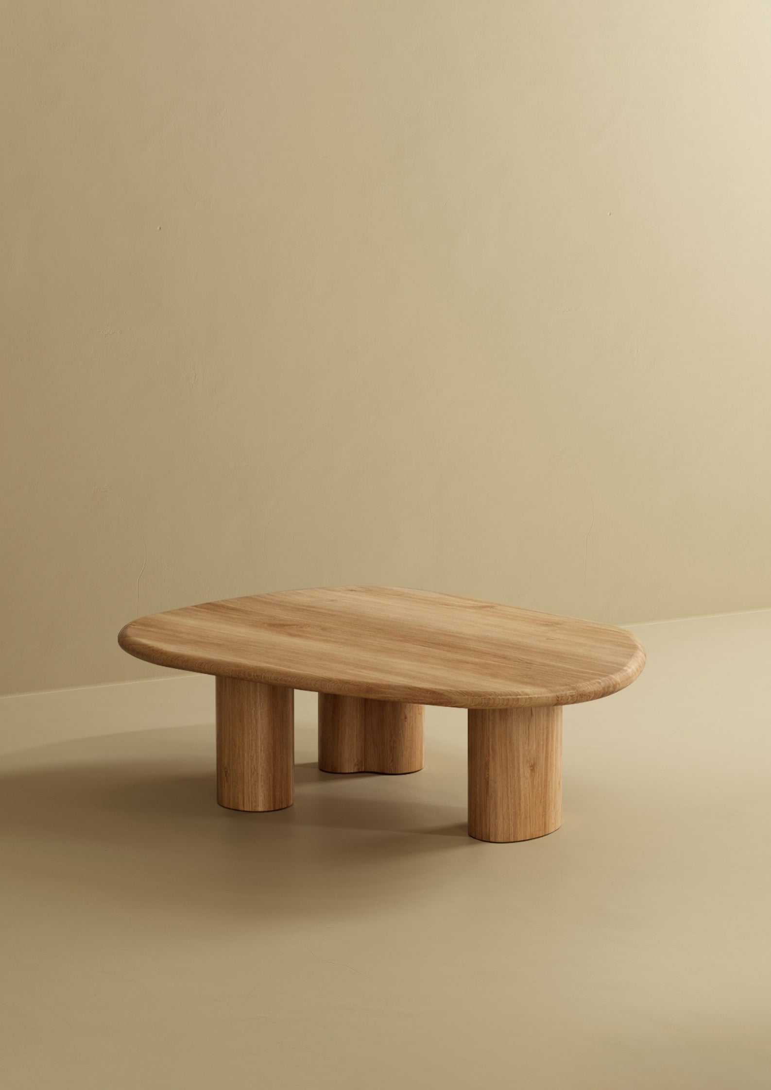 A low oak coffee table with an organic-shaped top and rounded legs.