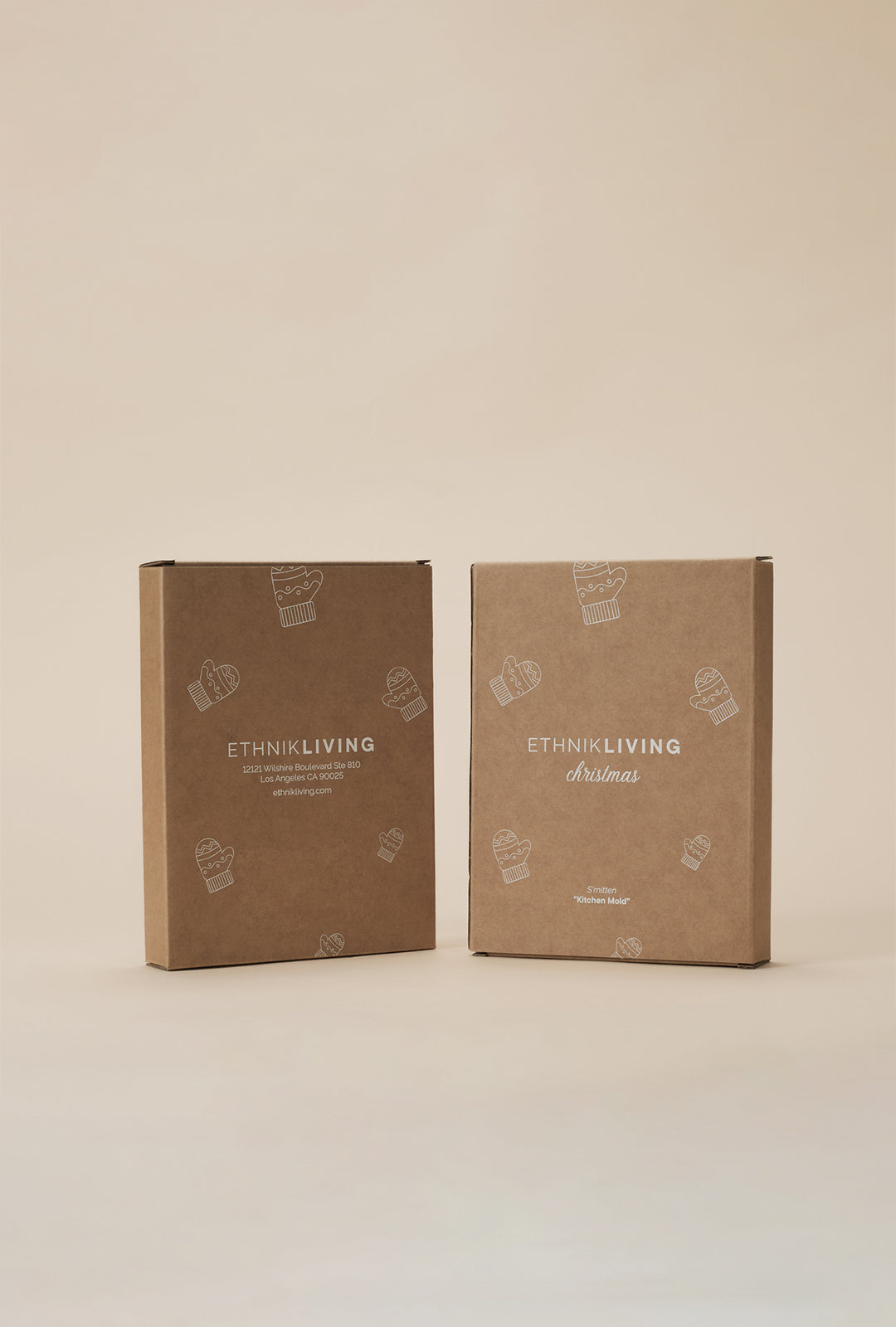 Two Ethnik Living Christmas branded cardboard boxes shown upright side by side, displaying the front and back packaging of the S’mitten Kitchen Mold.