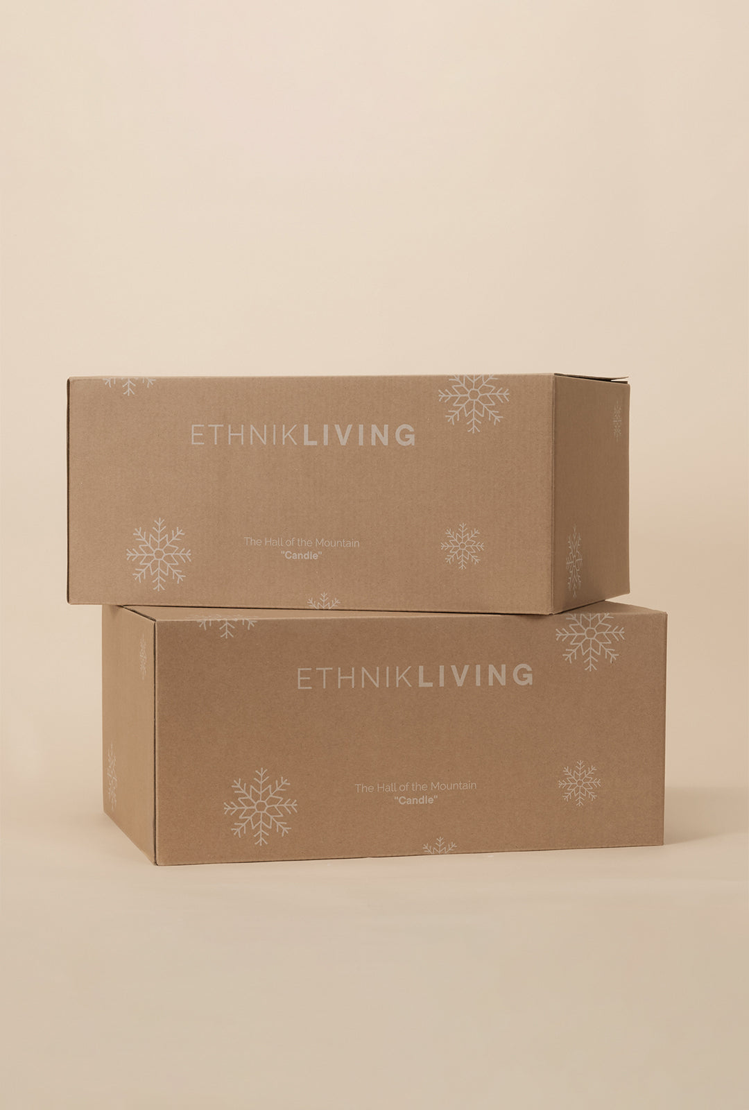 Stacked Ethnik Living packaging boxes with snowflake details, labeled “The Hall of the Mountain Candle,” on a neutral background.