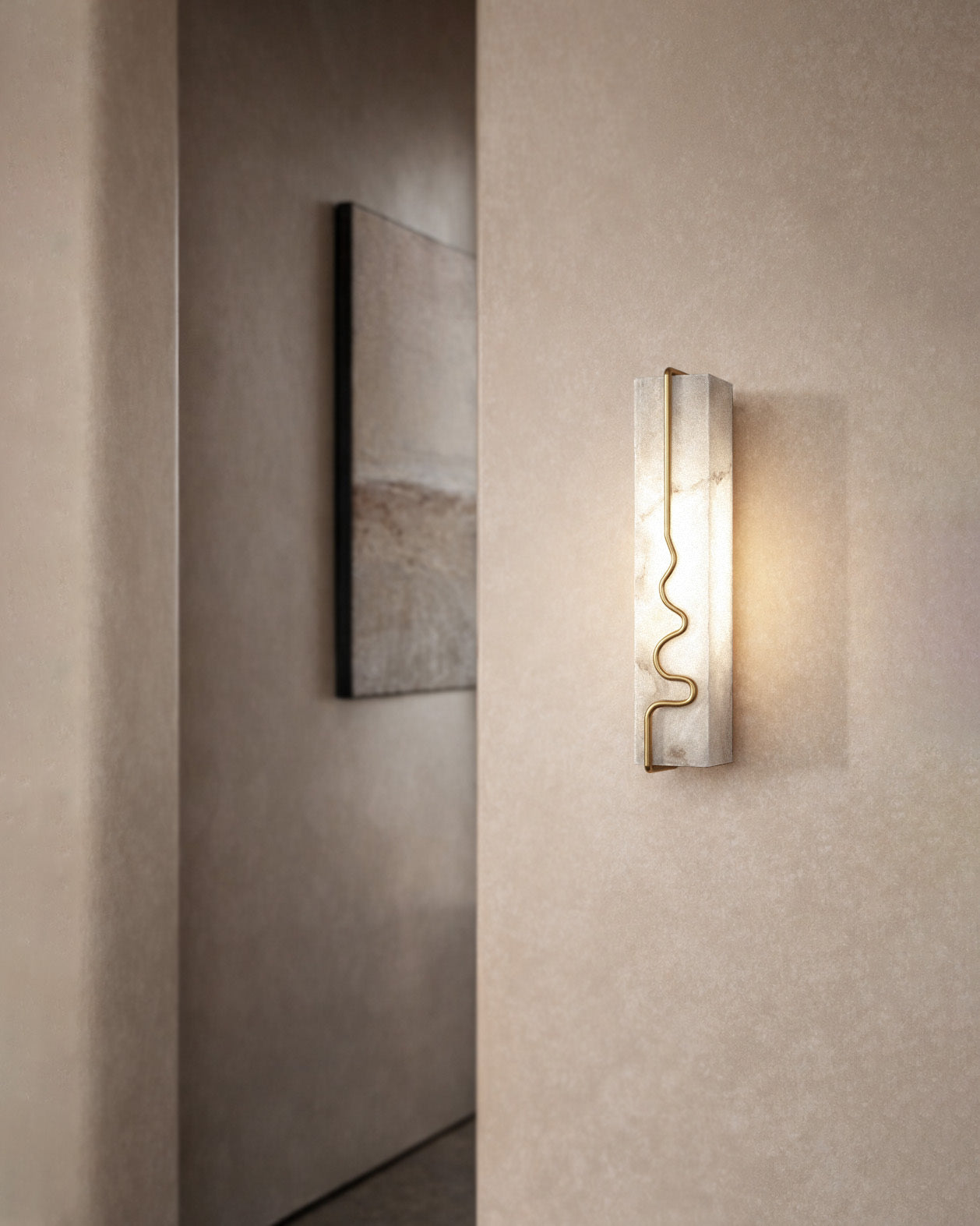 Alabaster wall sconce with brass detail casting warm light on a textured wall.