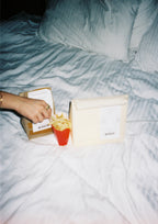 Lunch Bag Lamp styled on a bed with takeout packaging and French fries.