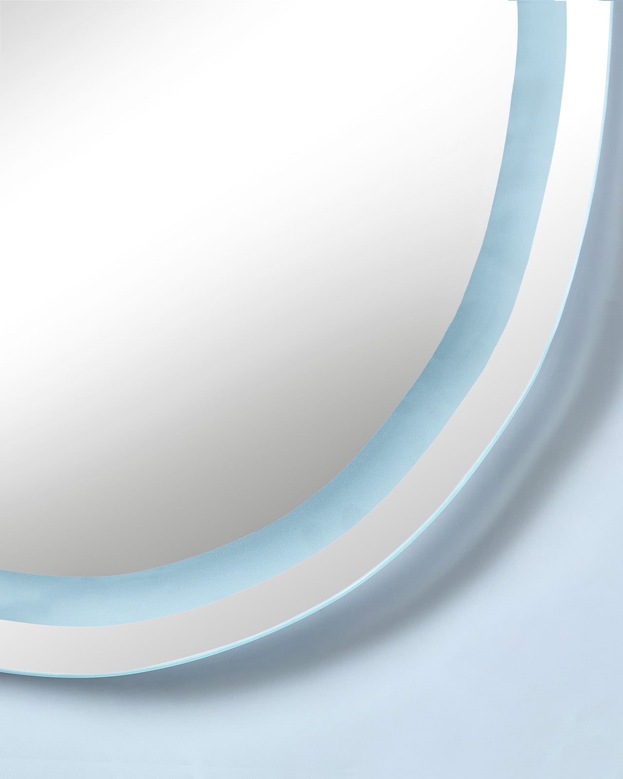 Close-up of an organic-shaped LED mirror with a cool white illuminated edge.