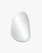 Organic-shaped LED mirror with subtle front-lit edge on a neutral background.