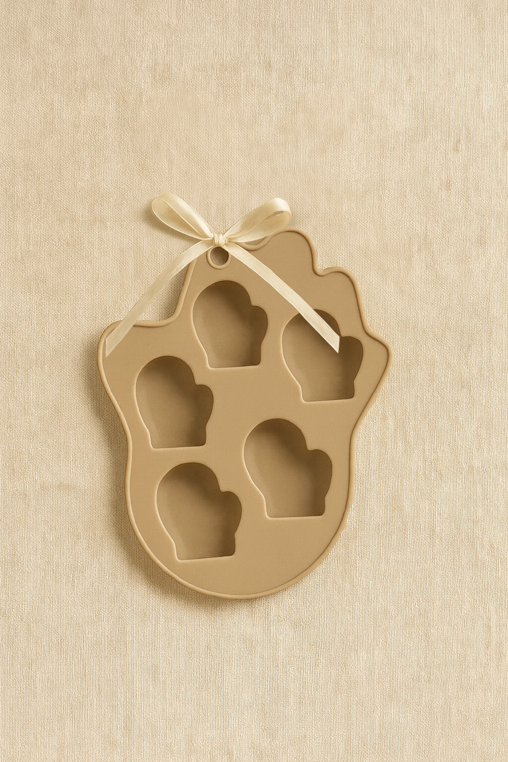 Empty beige mitten-shaped silicone kitchen mold with five cavities.